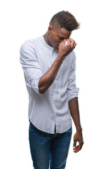 Young african american man over isolated background tired rubbing nose and eyes feeling fatigue and headache. Stress and frustration concept.