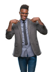 Young african american business man over isolated background looking confident with smile on face, pointing oneself with fingers proud and happy.