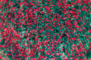 Whirling abstract pattern of red flowers with a blurred motion effect against a green background
