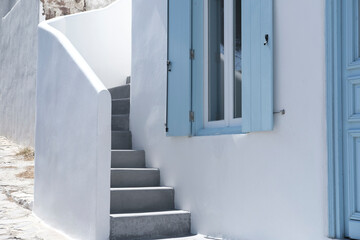 greek traditional island house with blue wooden windows and doors, whitewashed cement concrete...