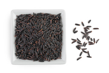 Black rice in a ceramic bowl isolated on white background. Top view. Flat lay