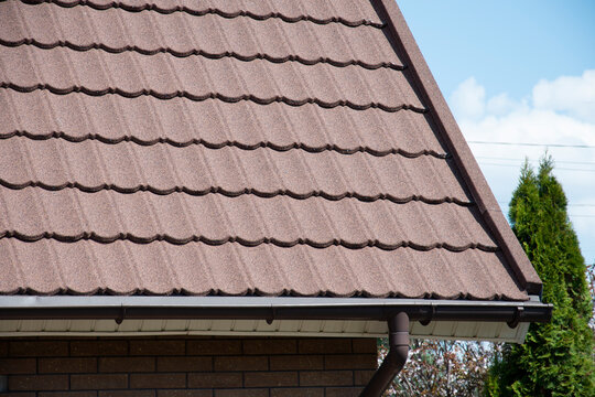 Composite roof tile on house with rain gutter