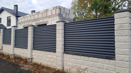 Modern stone fence with metal shutters