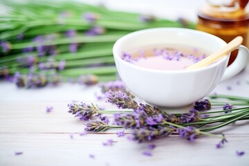 Obraz na płótnie Canvas fresh lavender sprigs beside purple-hued tea in cup