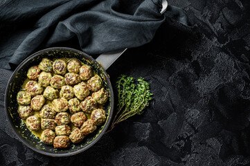 Swedish Meatballs with Cream Sauce in a skillet. Black background. Top view. Copy space