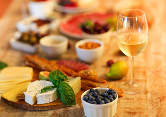 Dinner with snacks and wineglasses on table in living room