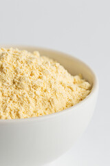 Soy  flour or soy protein isolate in white bowl  clouse up