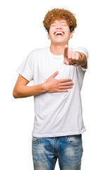 Young handsome man with afro hair wearing casual white t-shirt Laughing of you, pointing to the camera with finger hand over chest, shame expression