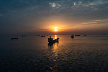 Fototapeta na wymiar Ships waiting at sea at sunset