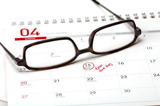 Close-Up 4K Ultra HD Image of Tax Due Date on Calendar with Eyeglasses