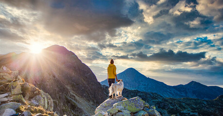 woman with white dog sitting on mountain top in summer landscape slow travel and freedom concept