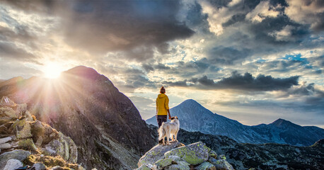 woman with white dog sitting on mountain top in summer landscape slow travel and freedom concept - Powered by Adobe