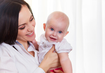 Happy smiling mother with six month old baby girl