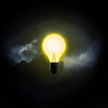 photo d'une ampoule allumée éclairant la nuit sombre symbolisant l'idée jaillissant de l'esprit, la lumière dans les ténèbres