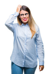 Fototapeta premium Young beautiful business woman wearing glasses over isolated background confuse and wonder about question. Uncertain with doubt, thinking with hand on head. Pensive concept.