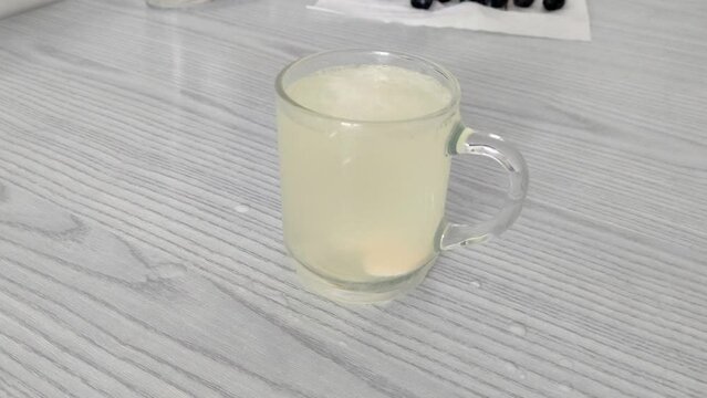 Man puts effervescent tablet into mug of water