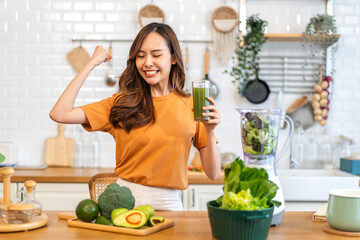 Obraz na płótnie Canvas Portrait of beauty healthy asian woman making green vegetables detox cleanse and green fruit smoothie with blender.young girl drinking glass of smoothie, fiber, chlorophyll in kitchen.Diet, healthy