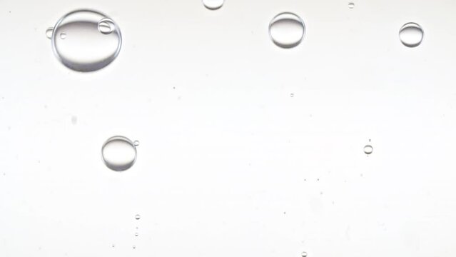 Clear Bubbles Form and Float to Another Ones on Transparent Surface on White Background. The Medicine Concept, Health Care, Body Care Cosmetics. Macro Shot. Slow Motion. High quality FullHD footage