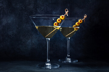 Martini. Two glasses of dirty martini cocktails with vermouth and olives, aperitif, on a black...