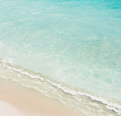 Turquoise water wave with sand beach from above, empty summer vacation background. Banner with copy space. Travel, holiday concept. Beautiful backdrop for presentation or product. Minimalist Flyer