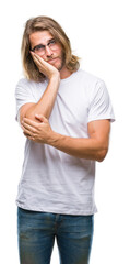 Young handsome man with long hair wearing glasses over isolated background thinking looking tired and bored with depression problems with crossed arms.