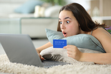 Amazed online buyer holding credit card