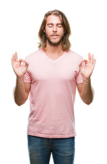 Fototapeta na wymiar Young handsome man with long hair over isolated background relax and smiling with eyes closed doing meditation gesture with fingers. Yoga concept.