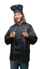 Young handsome cook man with long hair over isolated background pointing fingers to camera with happy and funny face. Good energy and vibes.