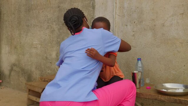 africa female black doctor nurse hug a little cute nice children in remote clinic hospital 