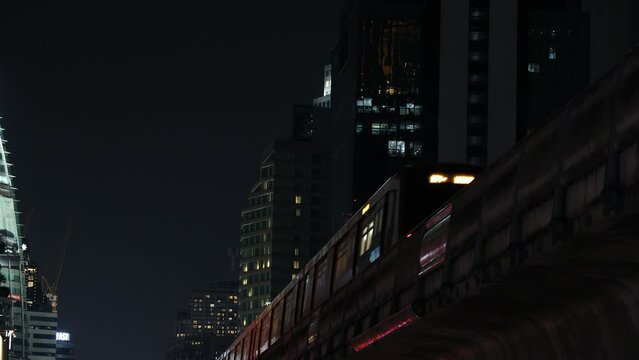 Train moving between buildings in modern city, urban view, bangkok Thailand