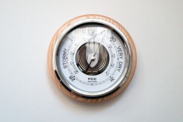 Large, analog weather pressure barometer showing both air pressure and associated weather...