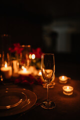 Champagne glasses, bouquet flowers. Candlelight date in restaurant. Romantic dinner setup at night....