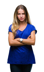 Young beautiful blonde woman over isolated background skeptic and nervous, disapproving expression on face with crossed arms. Negative person.