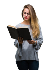 Young beautiful blonde woman reading a book over isolated background with a confident expression on smart face thinking serious