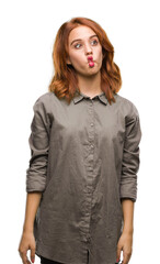 Young beautiful woman over isolated background making fish face with lips, crazy and comical gesture. Funny expression.