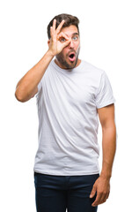 Obraz premium Young handsome man over isolated background doing ok gesture shocked with surprised face, eye looking through fingers. Unbelieving expression.