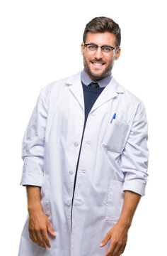 Young handsome man wearing doctor, scientis coat over isolated background looking away to side with smile on face, natural expression. Laughing confident.