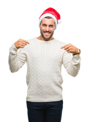Young handsome man wearing santa claus hat over isolated background looking confident with smile on face, pointing oneself with fingers proud and happy.