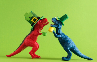 Red and blue dinosaurs in green hats with beer celebrating St. Patrick's day. Unusual festive card.