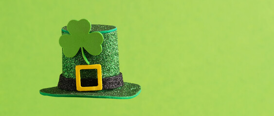 Green hat with clover leaf on green background.