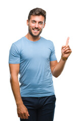 Fototapeta premium Young handsome man over isolated background with a big smile on face, pointing with hand and finger to the side looking at the camera.