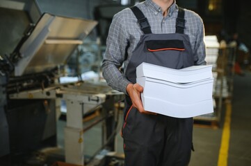 Man working in printing house with paper and paints