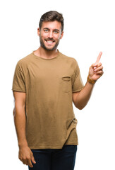 Young handsome man over isolated background with a big smile on face, pointing with hand and finger to the side looking at the camera.