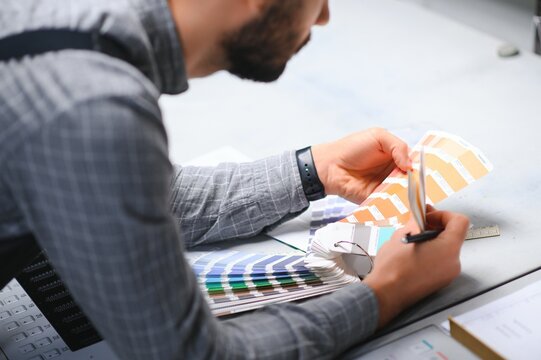 Typographer standing with color swatches at the printing manufacturing