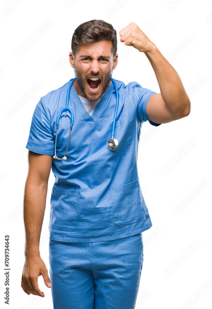 Poster Young handsome doctor surgeon man over isolated background angry and mad raising fist frustrated and furious while shouting with anger. Rage and aggressive concept.