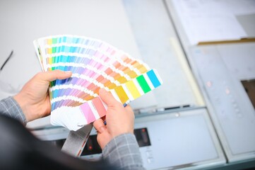 Typographer standing with color swatches at the printing manufacturing