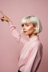 Portrait of a beautiful blonde woman in a pink shirt on a pink background
