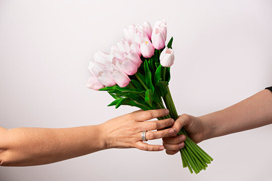 Manos con ramo de tulipanes rosas.