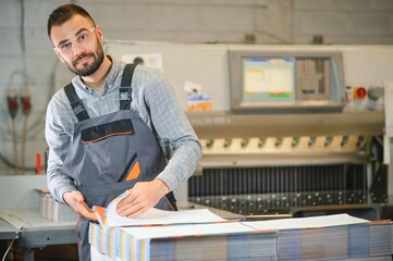 Man working in printing house with paper and paints