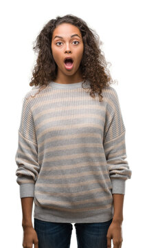 Beautiful young hispanic woman wearing stripes sweater afraid and shocked with surprise expression, fear and excited face.